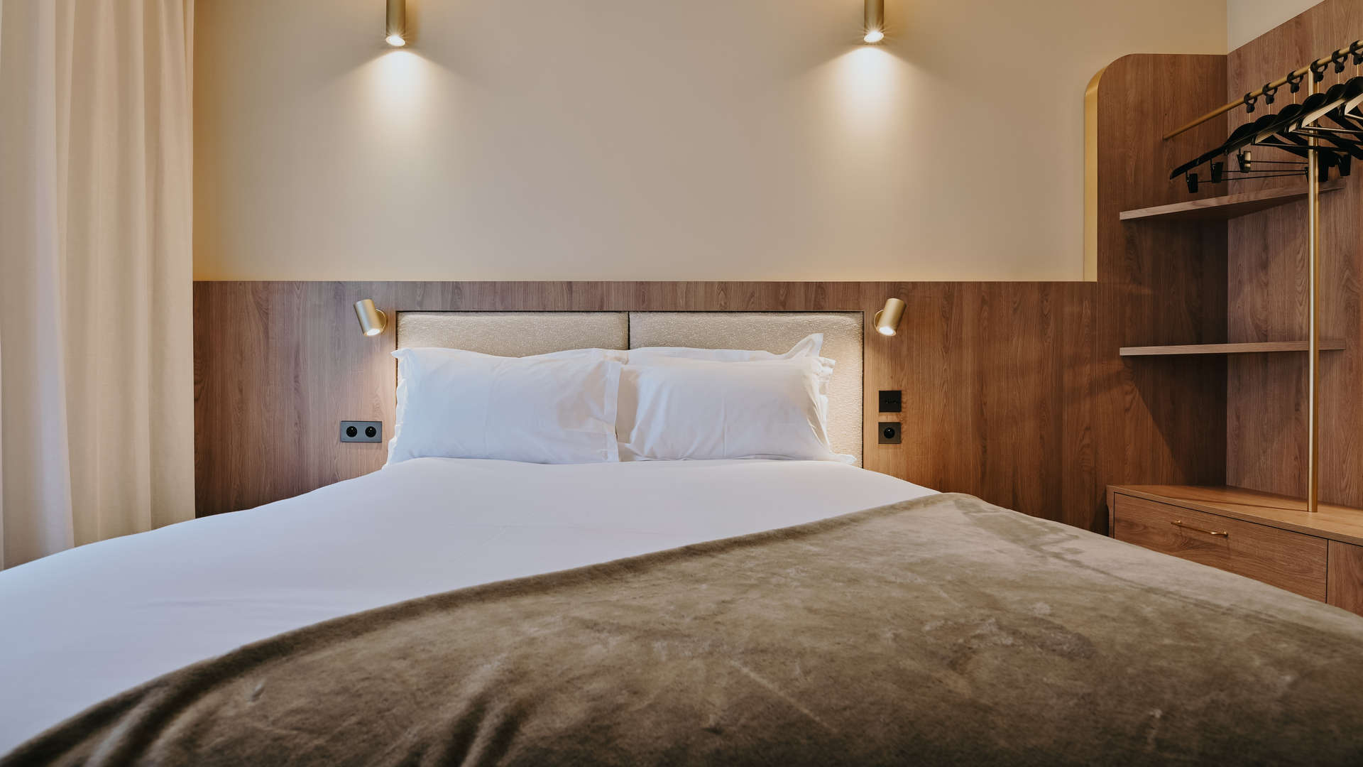 vue de face d'un lit avec une décoration murale en bois dans notre hôtel à confluence Lyon - Keystone 