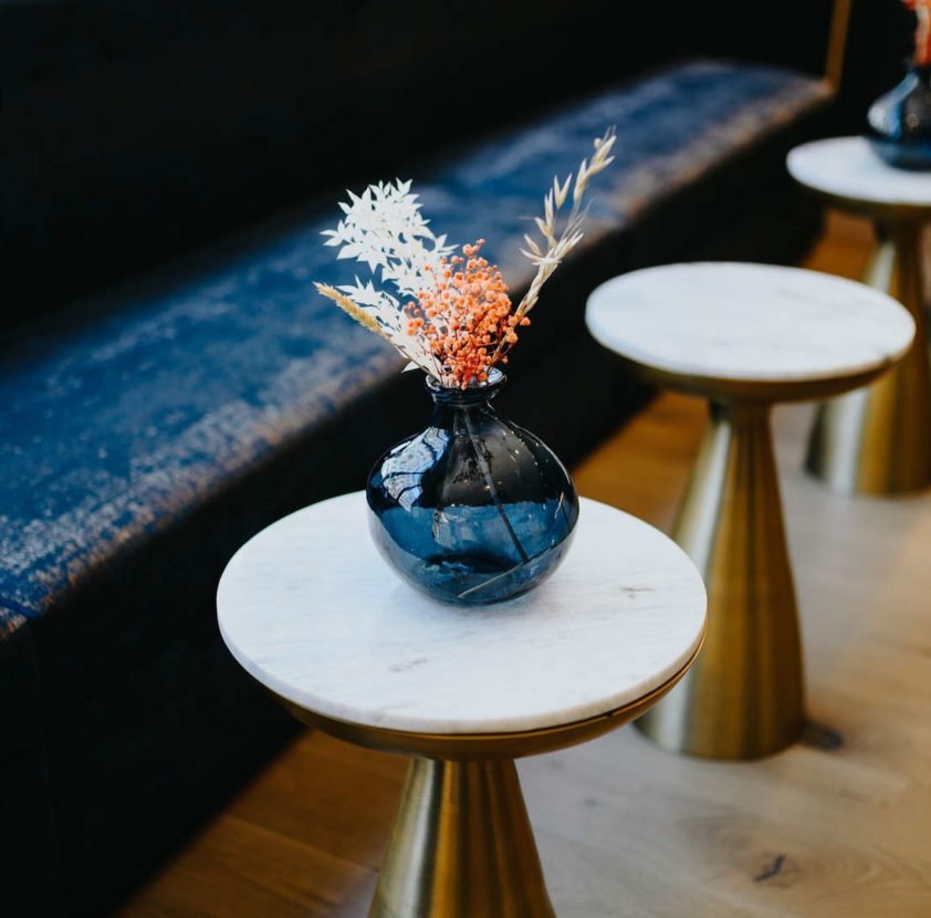 un banc avec des petites tables et un vase avec des fleurs séchées - hotel design Lyon - hotel Keystone